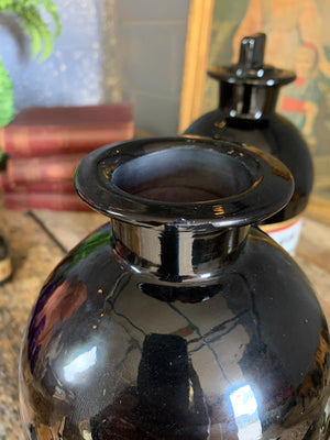 A pair of very large amethyst glass apothecary bottles