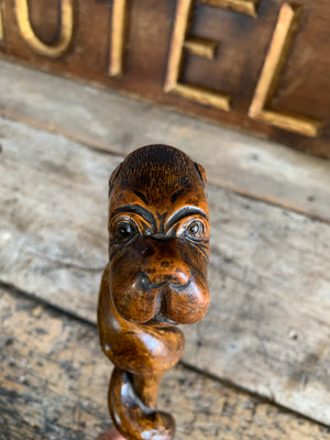 A wooden dog's head walking stick with glass eyes