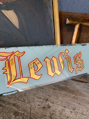 A reverse painted glass shop sign - T S Lewis