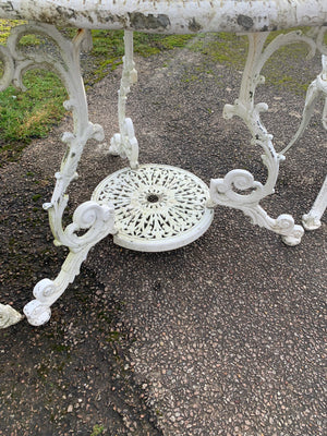 A white cast metal table and two chairs garden set