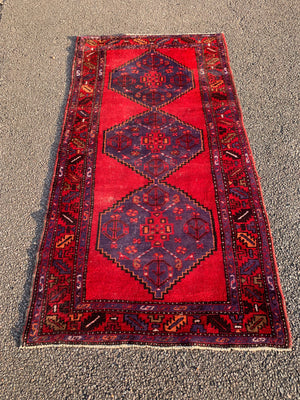 A red ground runner rug - 207cm x 108cm