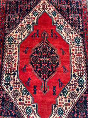 A hand woven Persian red ground rectangular Senneh rug