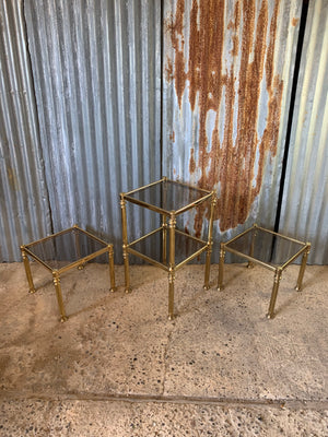 A set of four metamorphic square Hollywood Regency stacking side tables with smoked glass