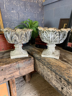 A pair of large tulip or acanthus pattern cast stone urns