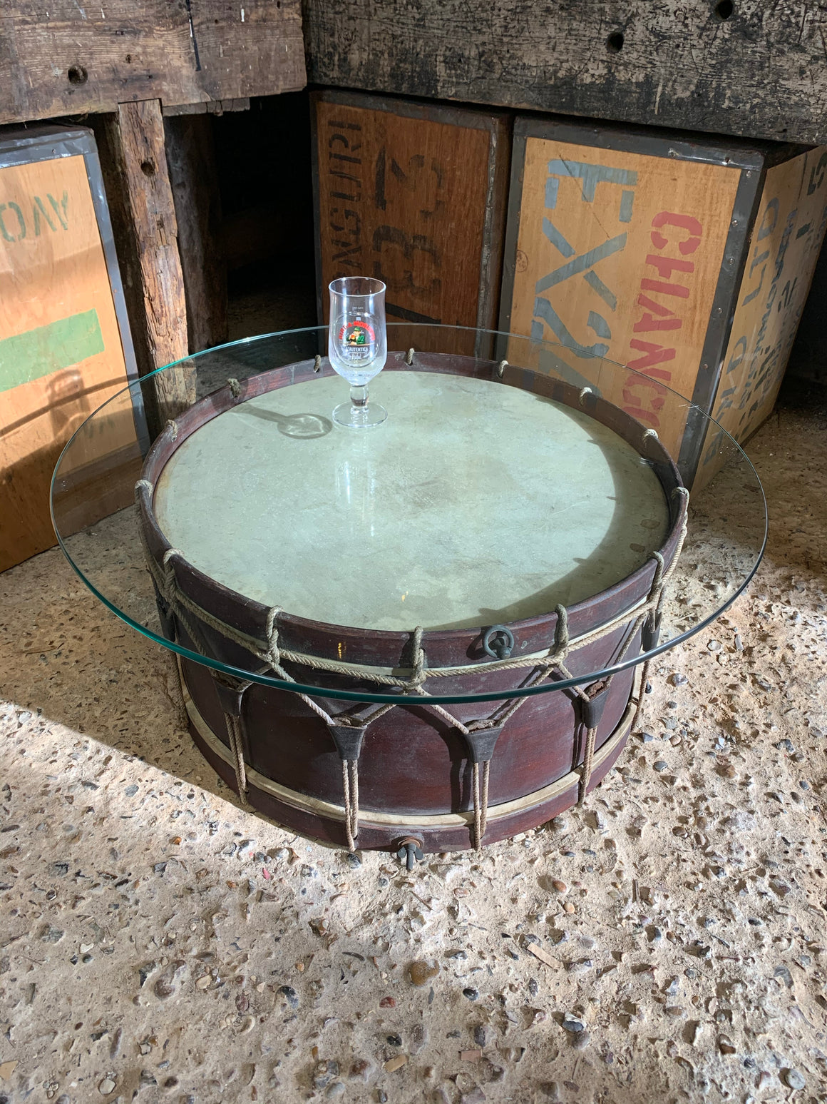 An antique wooden drum glass topped coffee table