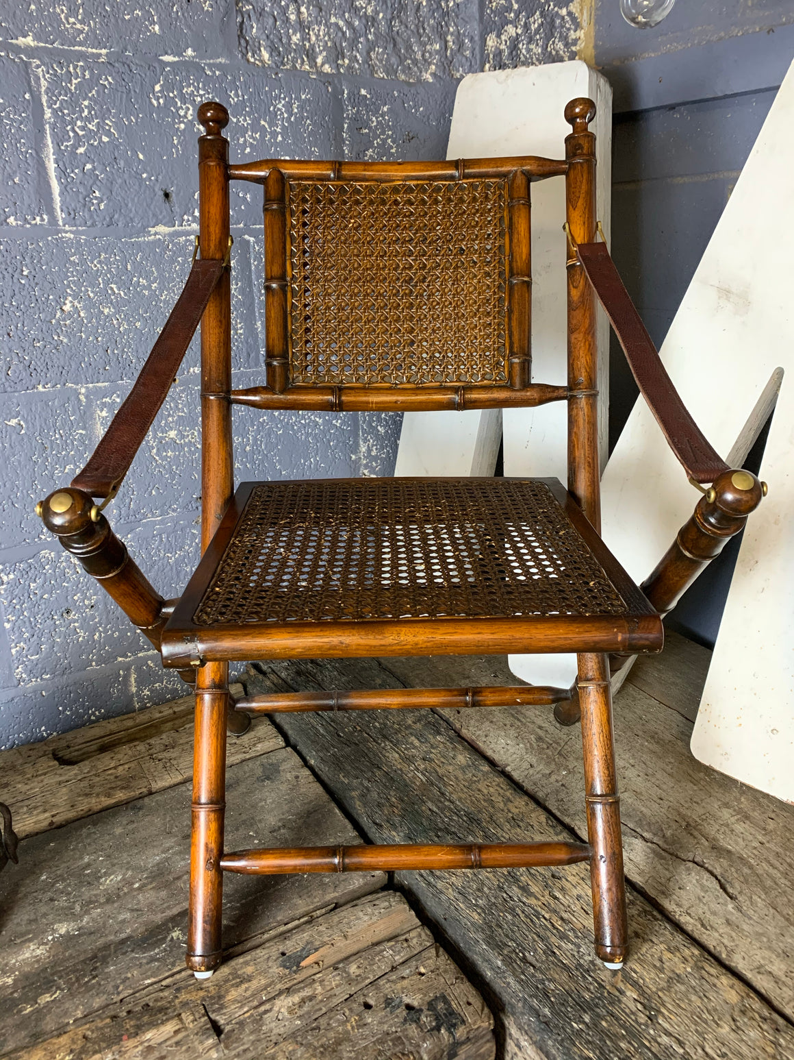 A faux bamboo carved hardwood folding campaign chair