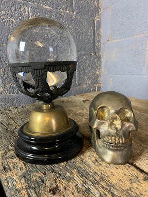 A fortune teller's crystal ball on a black and gold stand