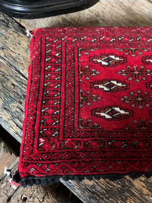 A red ground Persian carpet cushion