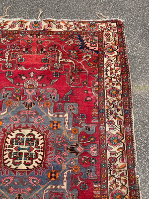 A large hand woven Persian red ground rectangular rug with bird motifs