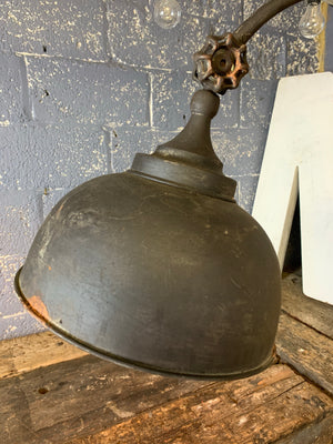 A rusty black metal adjustable vintage industrial floor lamp