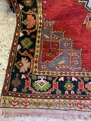 A large hand woven Persian red ground rectangular rug