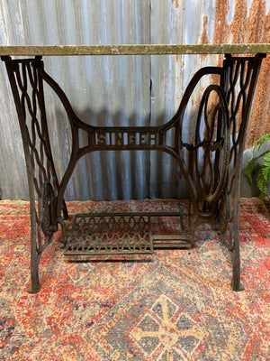 A cast iron Singer sewing table with marble top